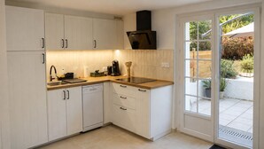 Una cocina moderna con armarios blancos, una campana extractora negra y un ventanal al exterior.