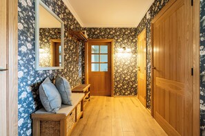 A hallway with a wooden bench, a mirror, and a door with a frosted glass panel. - English-style vacation home in Rechlin for 8 people with a fireplace in Rechlin Müritz (Rechlin)