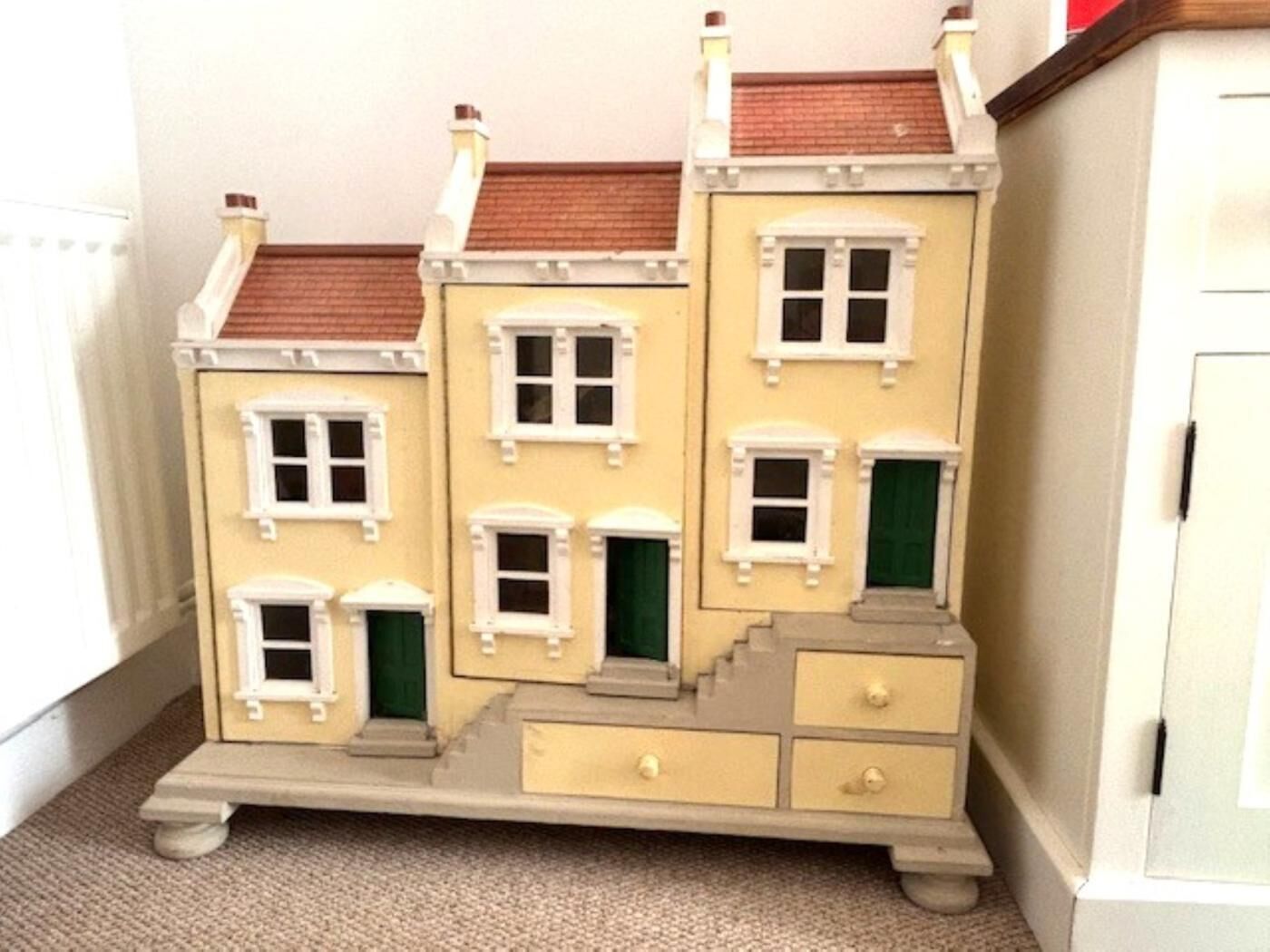 Model d'un edifici de diversos pisos amb nombroses finestres i portes, una xemeneia i una escala.