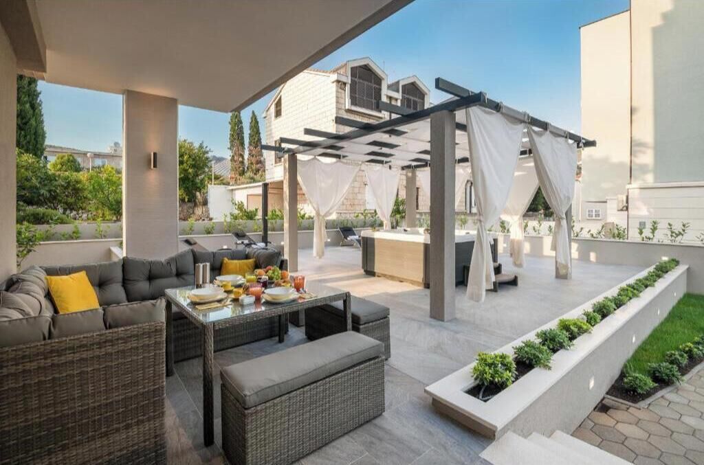An outdoor patio area with a sofa, table, and pergola.