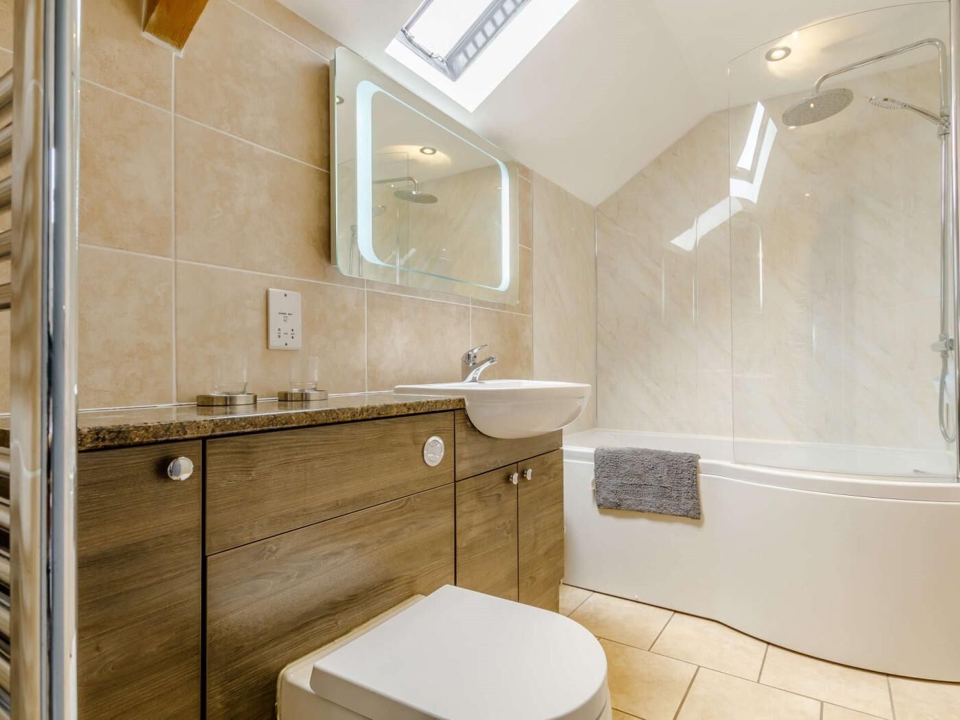 A modern bathroom with a skylight, a bathtub, and a vanity with a sink.