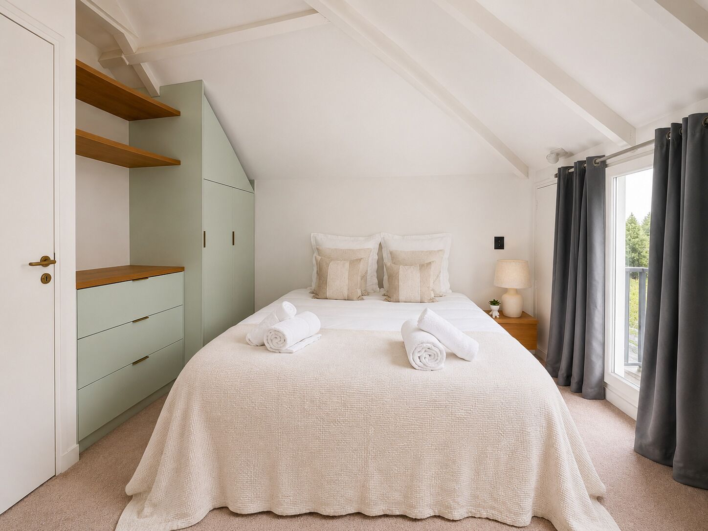 A bedroom with a bed, a wardrobe, a nightstand, and a window with curtains.