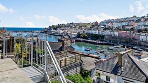 Une ville côtière dotée d’un port, de bâtiments et d’un escalier menant à une terrasse.
