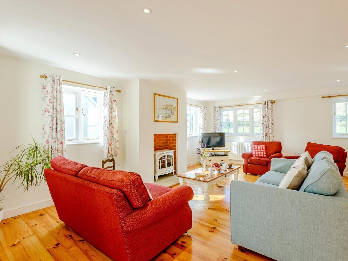 A living room with a fireplace, a television, and two sofas.