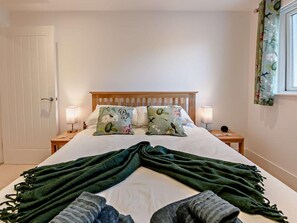 A bedroom with a bed, two bedside tables, a wooden headboard, and a door. - 2 Bed in Plymouth (oc-93195) (Plymouth)