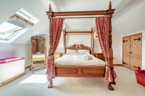 Ein Bett mit Baldachin, ein Holzschrank, ein Spiegel und eine rote Bank.
