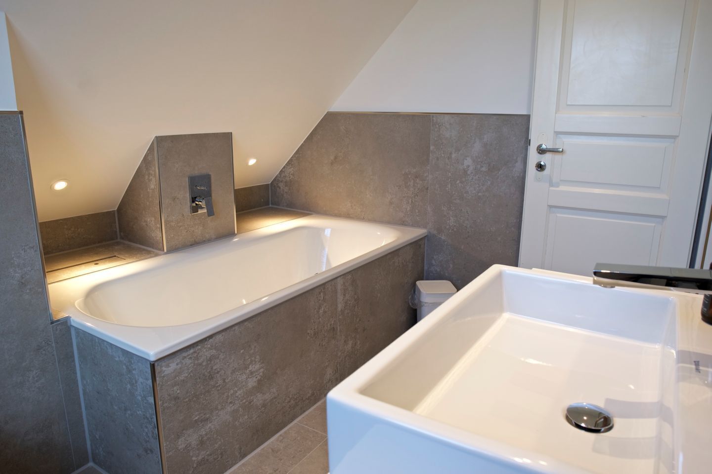 Een moderne badkamer met een vrijstaand bad, een douchegedeelte en een toilet.