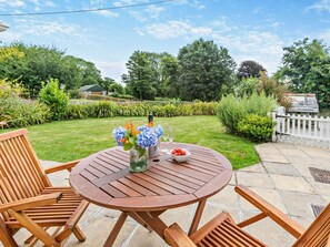 A round wooden table with chairs, a vase with flowers, and a bowl of fruit. - 2 Bed in Bodmin (oc-vinec) (Luxulyan)