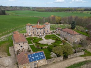A large stone building with a courtyard, surrounded by green fields and trees. - 1 Bed in Bedale (oc-g0044) (Patrick Brompton)