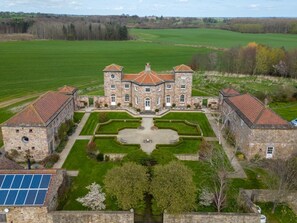 A large stone building with a symmetrical garden and a solar panel array. - 1 Bed in Bedale (oc-g0044) (Patrick Brompton)