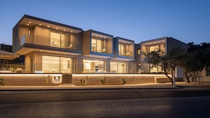 Een modern meerhoog appartementencomplex met balkons, grote ramen en een goed verlichte entree.