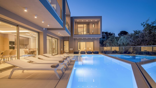 A modern outdoor pool area with lounge chairs and a glass-enclosed pool.