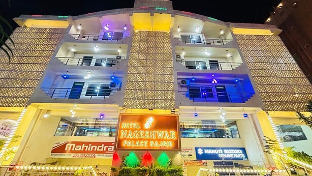 A multi-story hotel with a sign for 'Hotel Nageshwar Palace Rajgir' and 'Mahindra' branding. - Hotel Nageshwar Palace Rajgir (Rajgir)