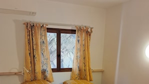 A single bed with a checkered bedspread, two pillows, and two rolled towels. - Domaine Anoutous, Carry – Peaceful Vacation Home Close to the Beach (Le Lavandou)