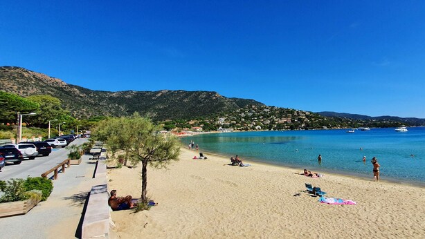 A beach with a clear blue sky, a sandy shore, and a few people relaxing. - Domaine Anoutous, Carry – Peaceful Vacation Home Close to the Beach (Le Lavandou)