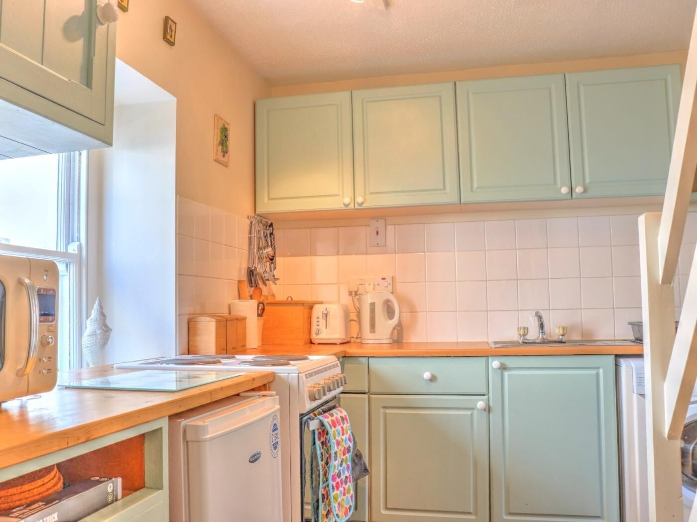 A kitchen with a stove, oven, and a coffee maker.