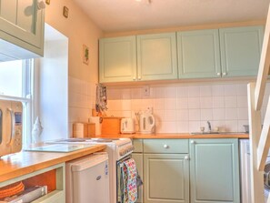 Een oven, een kinderstoel, kookgerei, borden en bestek