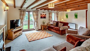 A spacious living area with a wooden ceiling, a television, a sofa set, a patterned rug, and a fireplace. - 4 Bed in Holsworthy (oc-lamer) (Holsworthy Hamlets)