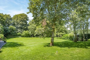A well-maintained grassy area with a variety of trees and shrubs, a paved path, and a small structure. - 1 Bed in Tavistock (oc-highm) (Cudlipptown)