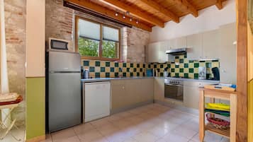 Una cocina compacta con refrigerador, microondas, lavavajillas y estufa.