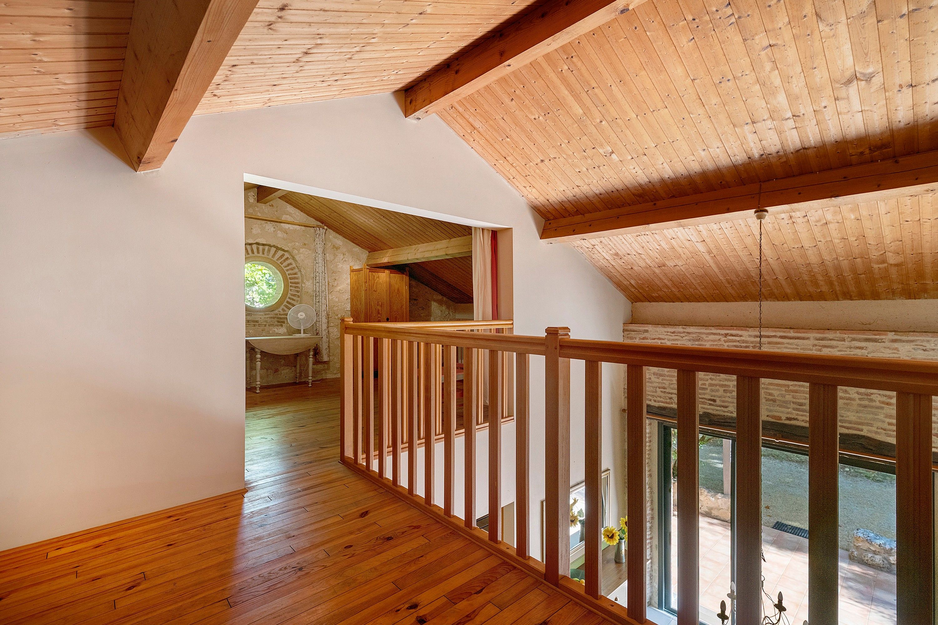 A wooden interior with a high ceiling and a view of the outdoors through a window.