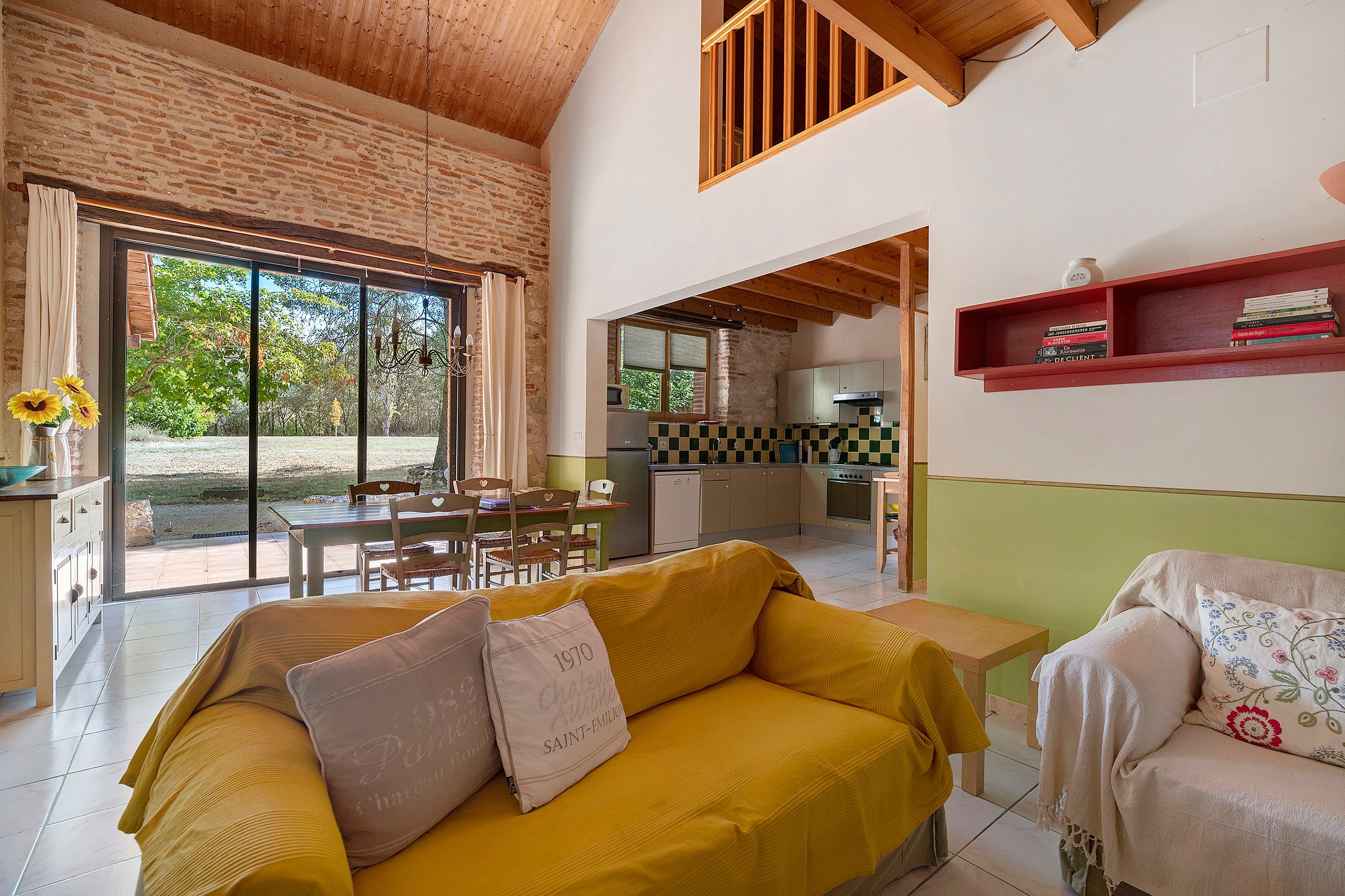 A modern interior with a yellow sofa, a dining area, and a kitchen.