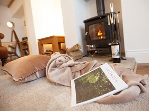 A cozy living room with a fireplace, a wine bottle, and a book titled 'STORIES'. - 1 Bed in Middlesbrough (oc-g0080) (Great Broughton)