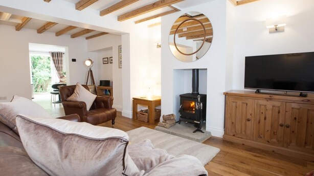 Ein gemütliches Wohnzimmer mit Kamin, Fernseher und Ledersofa.
