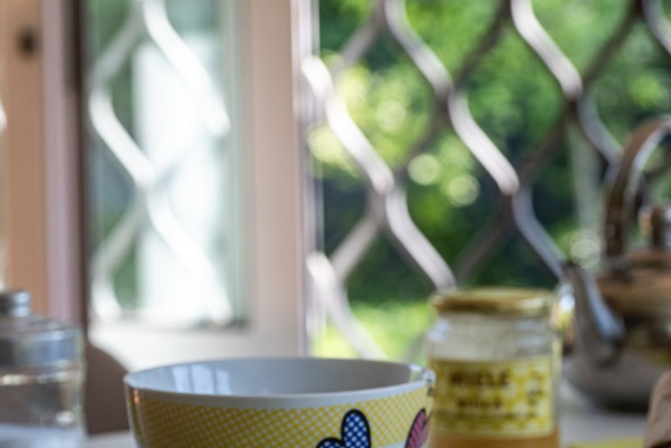 Una mesa de comedor con un bol, un vaso y un tarro.