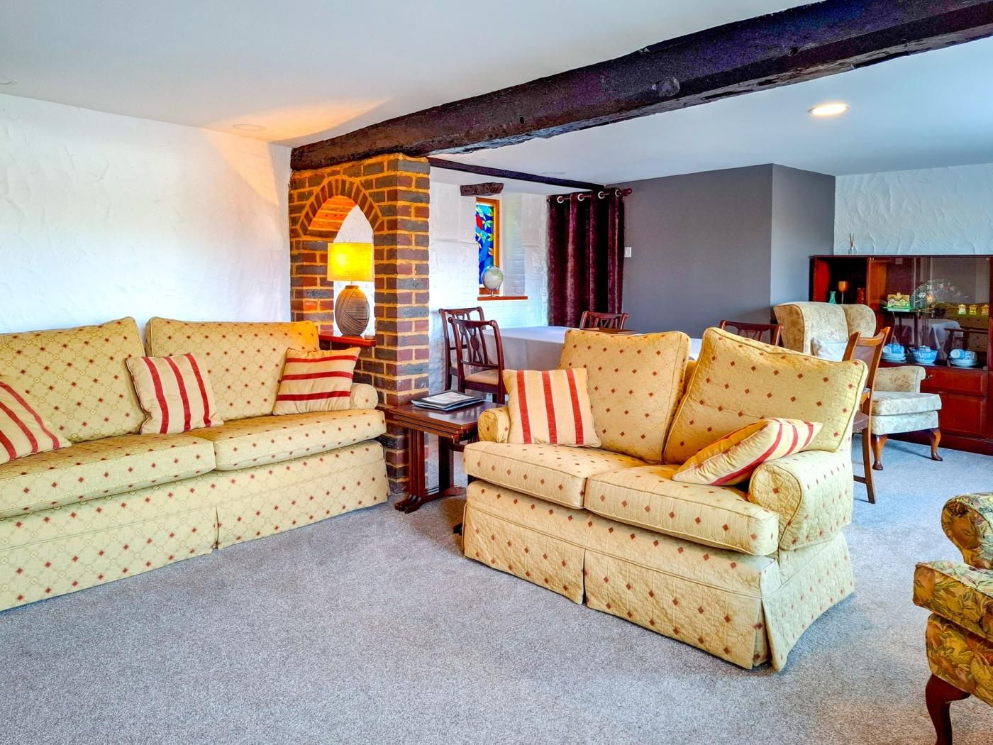 A living room with two sofas, a coffee table, and a brick fireplace.