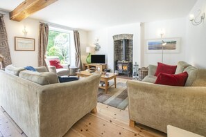 A living room with sofas, a TV, a fireplace, and a window with curtains. - 3 Bed in Bideford (oc-oldsb) (Buck's Mills)