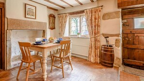 A rustic dining room with wooden furniture, a stone fireplace, and a wooden barrel. - 2 Bed in Matlock (oc-pk885) (Winster)