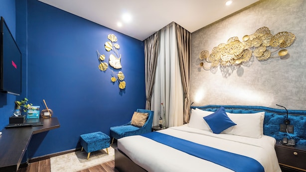 A modern bedroom with a large bed, a desk, a chair, and a TV. - Home Park Hotel HCM (Ho Chi Minh City)