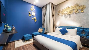 Ein modernes Schlafzimmer mit einem großen Bett, einem Schreibtisch, einem Stuhl und einem Fernseher.