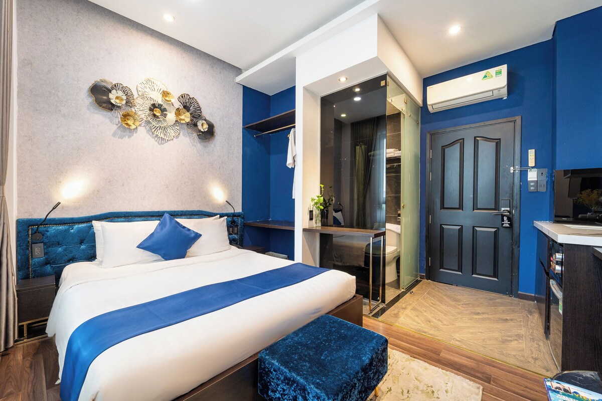 Ein modernes Hotelzimmer mit einem großen Bett, einem Schreibtisch und einem durchgegangenen Tür erkennbaren Badezimmer.