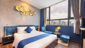 Camera d'albergo moderna con un letto grande, vista sulla città, una parete d'accento blu e un elemento decorativo a parete.