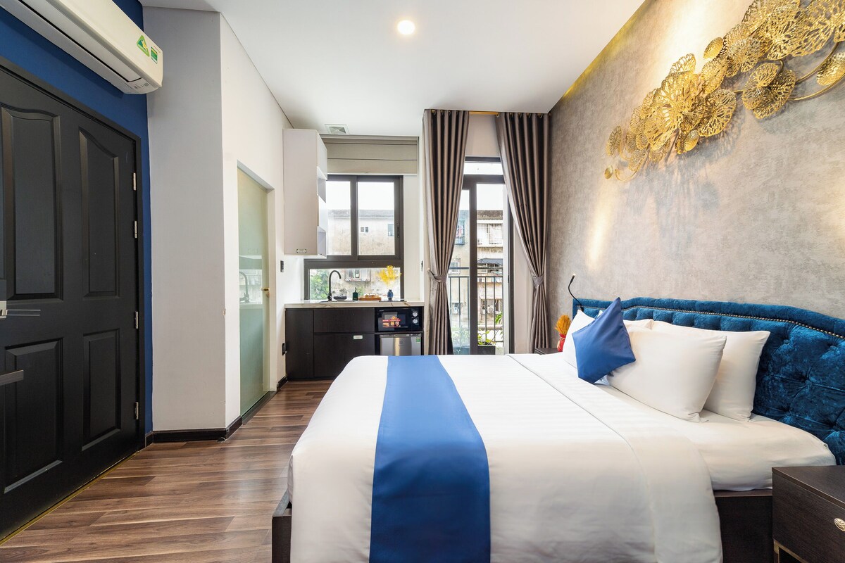 Een hotelkamer met een bed, een bureau, een raam en uitzicht op buiten.