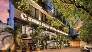 A hotel with a sign reading 'HOME PARK HOTEL & LUXURY APARTMENT' and a covered parking area. - Home Park Hotel HCM (Ho Chi Minh City)