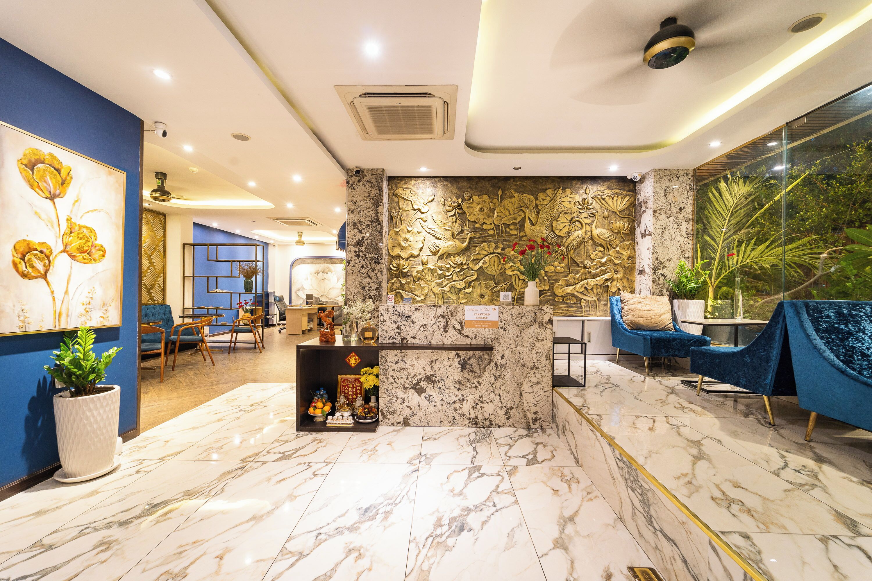 Een hotel lobby met marmeren vloeren, blauwe wanden en een receptiebalie.