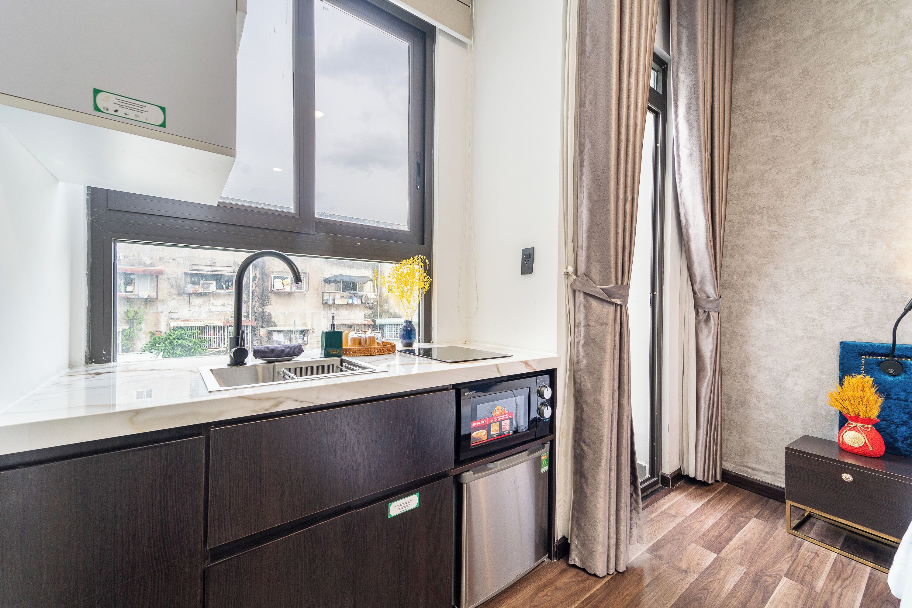 A modern kitchen with a large window, built-in appliances, and a view of the city.
