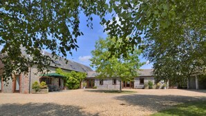 A rural property with stone buildings, a gravel courtyard, and a large tree providing shade. - 3 Bed in Sherborne (oc-folwr) (Folke)