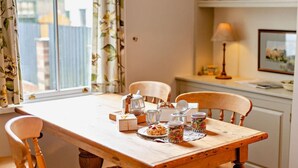 A dining table with chairs, a teapot, a plate with food, and a jar. - 2 Bed in Harrogate (oc-hh037) (Harrogate)