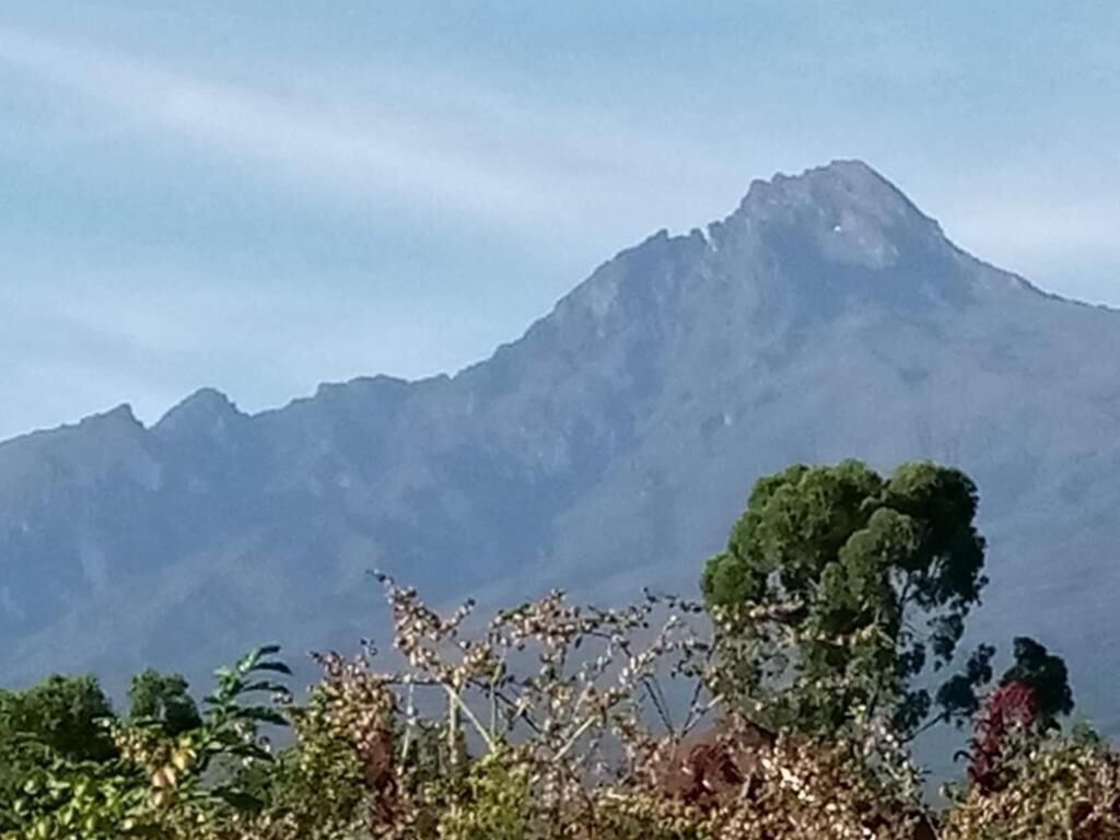 Ein Berg mit einem Gipfel im Hintergrund.