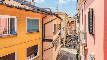 Une rue étroite, bordée de bâtiments des deux côtés, avec des balcons et des fenêtres.