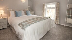 A bedroom with a bed, bedside tables, a window with curtains, and a headboard. - 2 Bed in Sandsend (oc-g0128) (Sandsend)