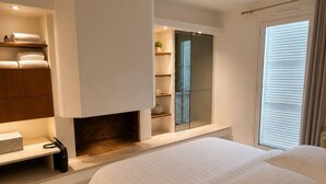 Un dormitorio moderno con una cama grande, estanterías empotradas, un espejo y una ventana con persianas.