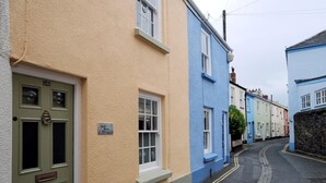 Une rue étroite bordée de maisons aux couleurs vives, chacune ayant une façade particulière.
