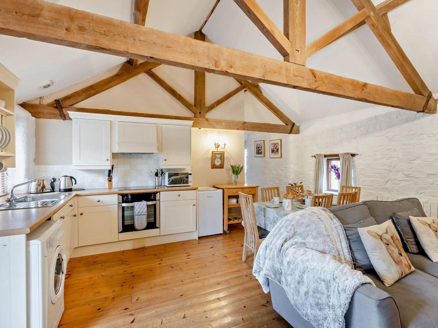 A cozy interior with a kitchen, dining area, and a sofa.
