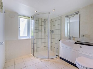 A bathroom with a glass-enclosed shower, a white sink, a mirror, and a toilet. - 2 Bed in Bideford (oc-fordm) (Woolfardisworthy)