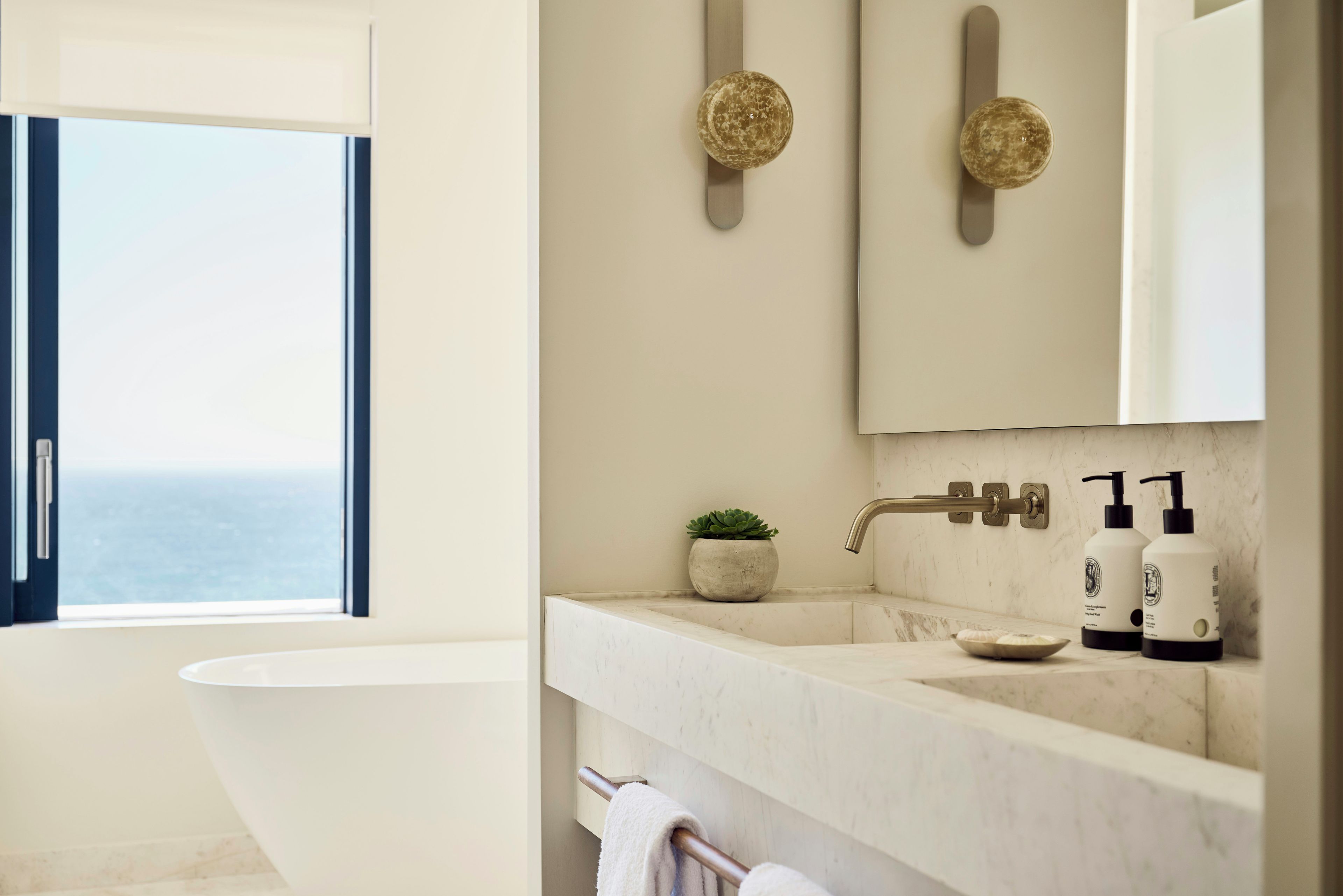 A modern bathroom with a bathtub, a sink with a faucet, and a mirror above the sink.